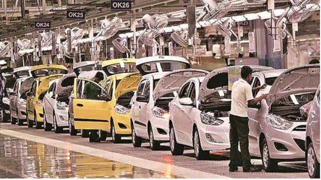 "Auto industry worker operating machinery without proper safety gear"